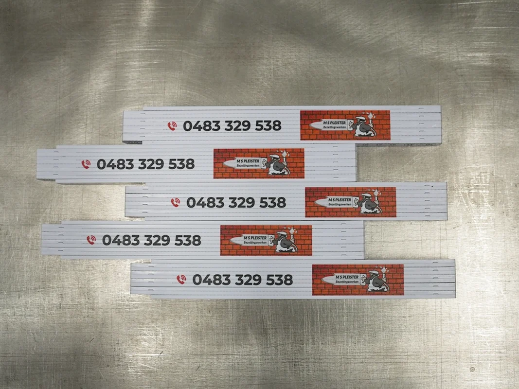 Miary składane z nadrukiem telefonu. Produkcja miar reklamowych z logo branży budowlanej, gadżety firmowe.