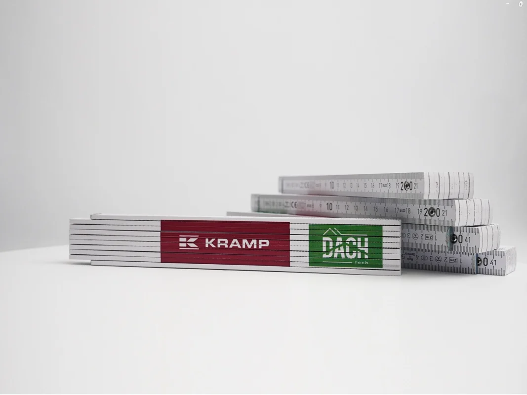 Miary składane z logo Kramp i Dach Fach. Produkcja personalizowanych miar reklamowych, gadżety firmowe.
