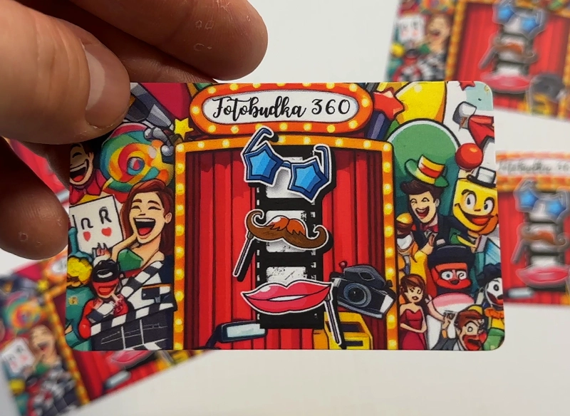 Wizytówka reklamowa trzymana w ręce, kolorowa, kreskówkowa grafika. Wizytówka fotobudka.