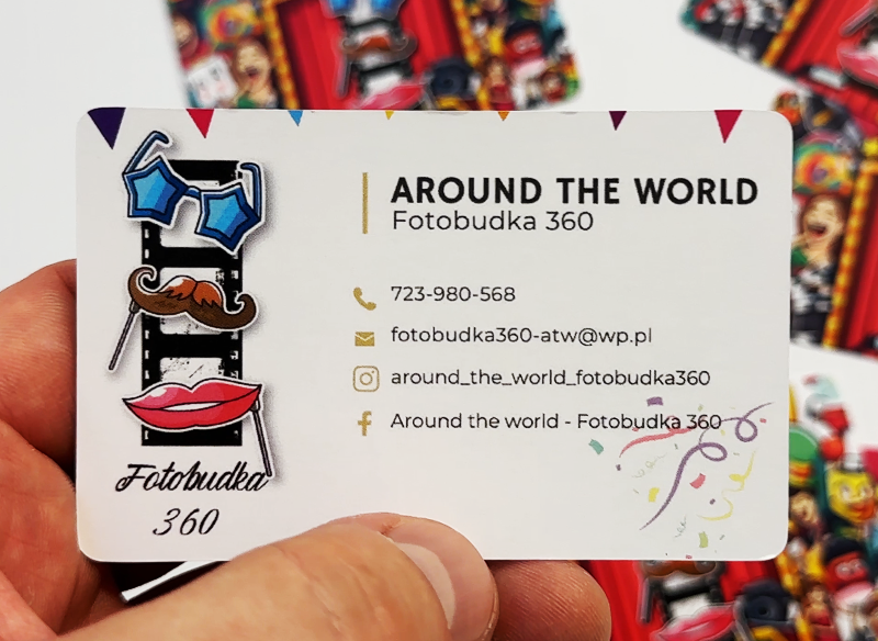 Wizytówka reklamowa trzymana w ręce, biała z grafikami rekwizytów do zdjęć.