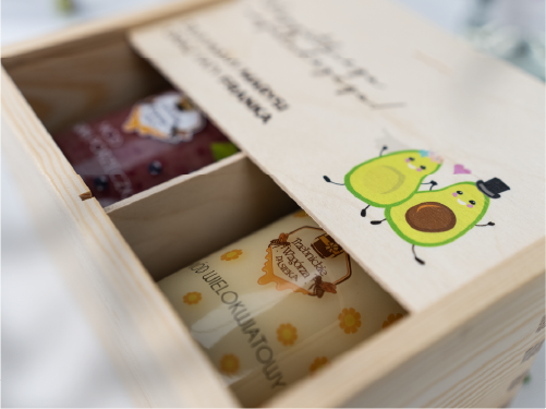 Drewniana skrzynka na miody. Personalizowane opakowanie prezentowe z nadrukiem i grafiką avocado.