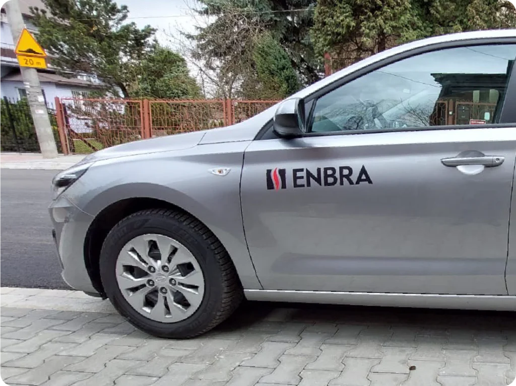 Oklejanie auta osobowego. Branding mobilny z logo ENBRA, reklama na samochodzie firmowym.