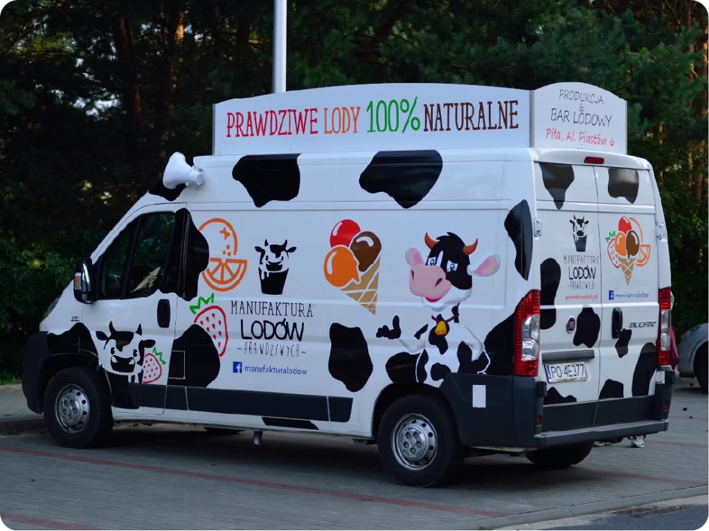 Oklejanie busa lodziarni. Kolorowa reklama mobilna, branding food trucka z grafiką krów i lodów.