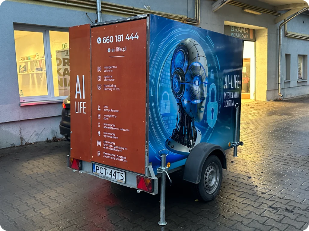 Oklejanie przyczepy reklamowej. Grafika na mobilnej reklamie, branding AI Life z listą usług i kontaktem.
