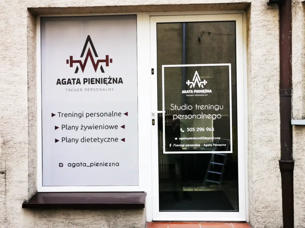 Oklejanie witryny studia treningu folią OWV. Reklama na szybach z ofertą personalnych planów treningowych.